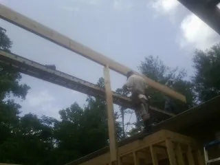 Carpenter setting a ridge beam over a new addition frame — Ice Dam Removal by Roofing Brothers in West Fargo
