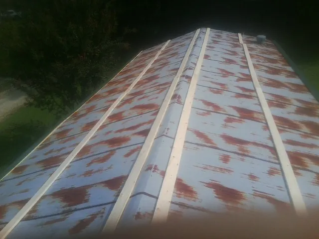 Rusted metal roof panels with new wood purlins before replacement — Storm Damage Roof Repair in West Fargo by Roofing Brothers