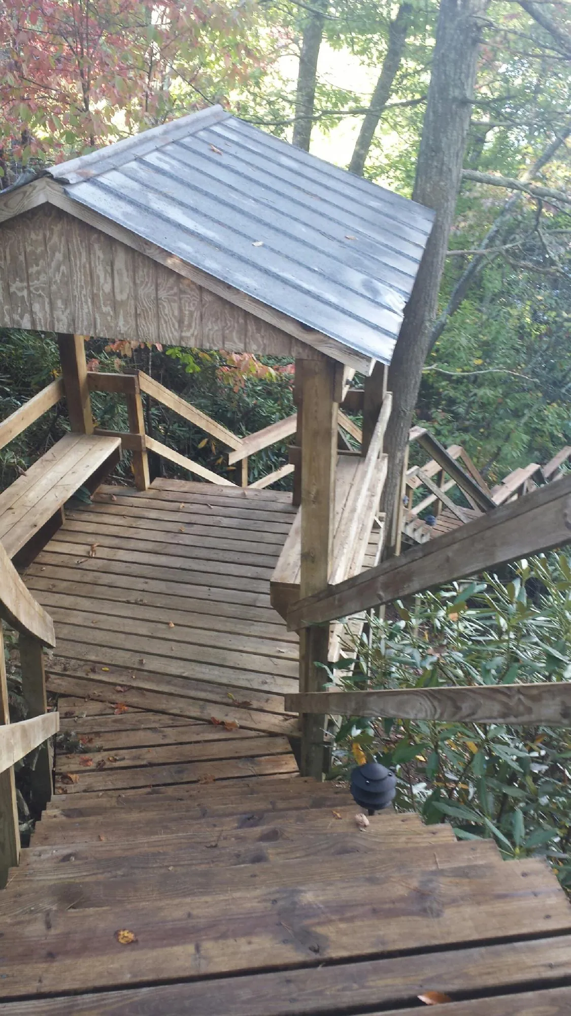 Metal roofed shelter over wooden steps on a wooded walkway — Skylight Repair & Installation work by our crew in West Fargo