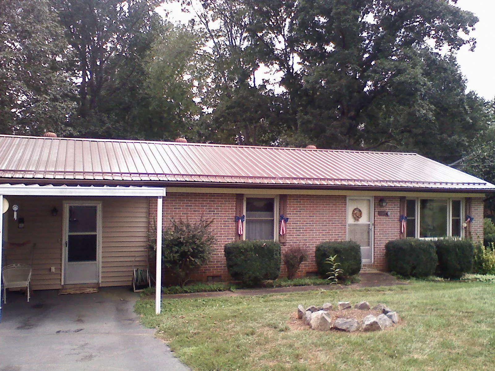 Bronze metal roof and carport on a brick ranch home — Roof Repair work by our crew in West Fargo